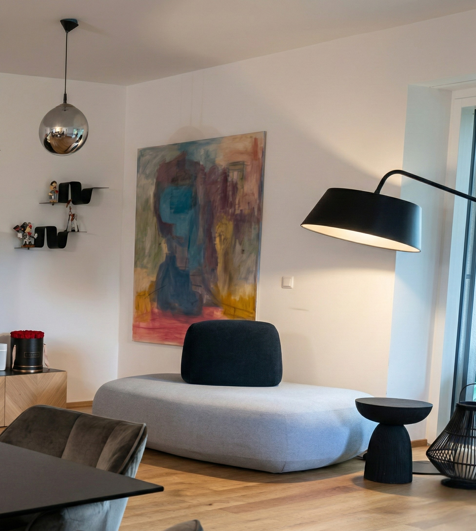 Vienna apartment — abstract art, sculpted sofa, globe pendant