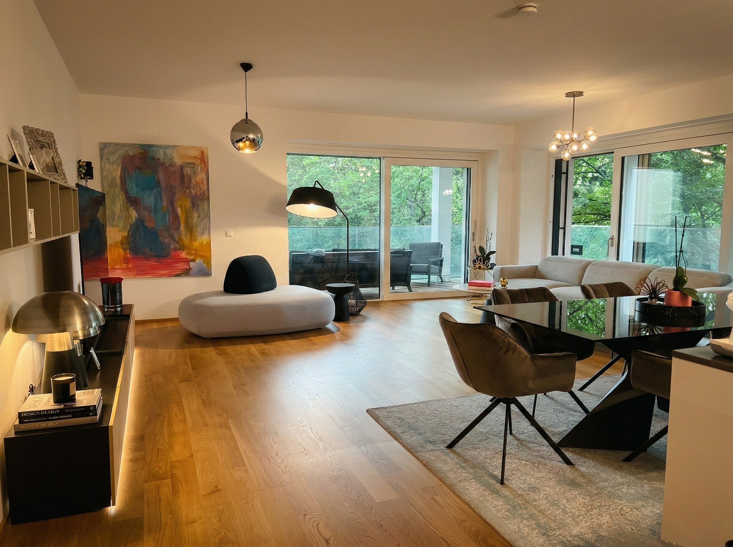 Open plan living room — colourful artwork, garden terrace beyond